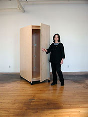 Art Storage Cabinet with locking doors is mobile on wheels.